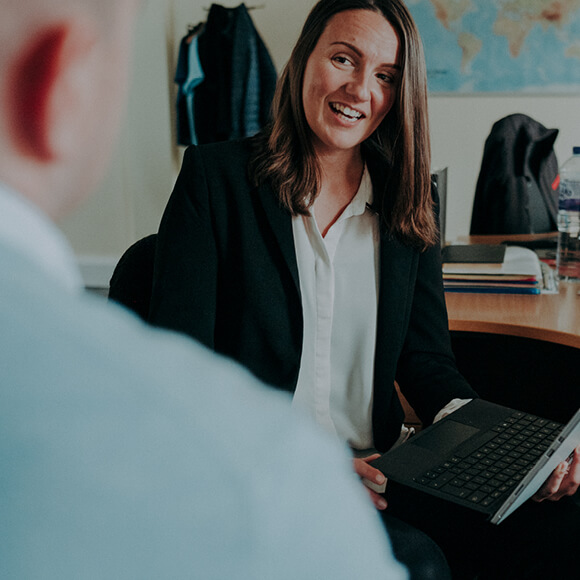 Two Tensar employees having a conversation, one holding a laptop